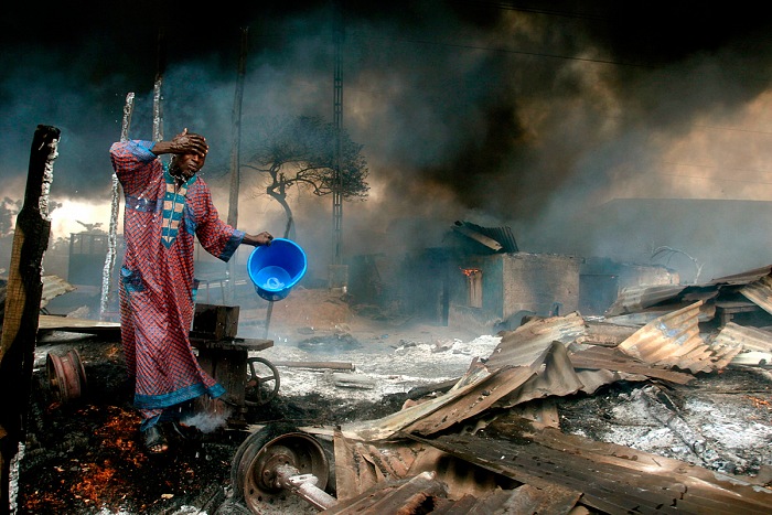 Akintunde Akinleye, A man rinses soot from his face at the scene of a gas pipeline explosion near Nigeria's commercial capital Lagos, December 26th, 2006.  Akintunde Akinleye/Reuters