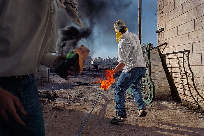 James Nachtwey, Protesters throwing petrol bombs during clashes between the Israeli troops and the local Palestinian population, Occupied Territories, West Bank, 2000.  James Nachtwey/Trustees of Dartmouth College