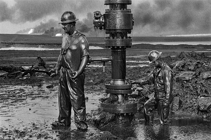 Sebastio Salgado, I lavoratori installano un nuovo pozzo. Pozzi di petrolio, Greater Burhan, Kuwait, 1991.  Sebastio Salgado/Amazonas Images/Contrasto