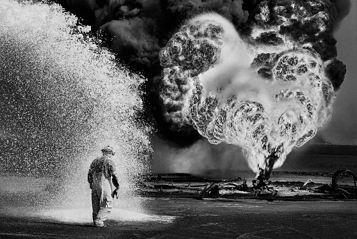 Sebastio Salgado, Spray chimici proteggono questo pompiere dal calore delle fiamme. Pozzi di petrolio, Greater Burhan, Kuwait, 1991.  Sebastio Salgado/Amazonas Images/Contrasto