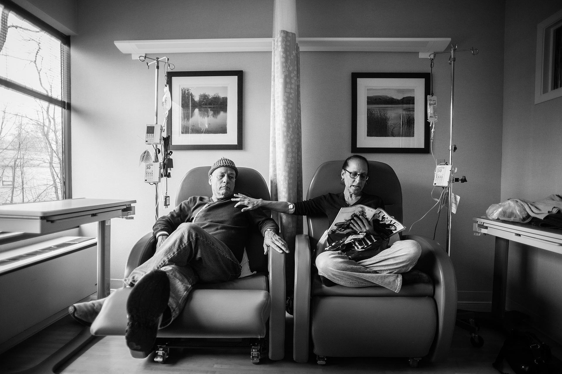Howie le chiama le sedie “di lui e di lei”. Siede al fianco di Laurel, sua moglie da 34 anni, durante la loro seduta settimanale di chemoterapia, presso l’ambulatorio dell’oncologo, il dottor Berry. Greenwich, Connecticut. Gennaio, 2013. © Nancy Borowick.
