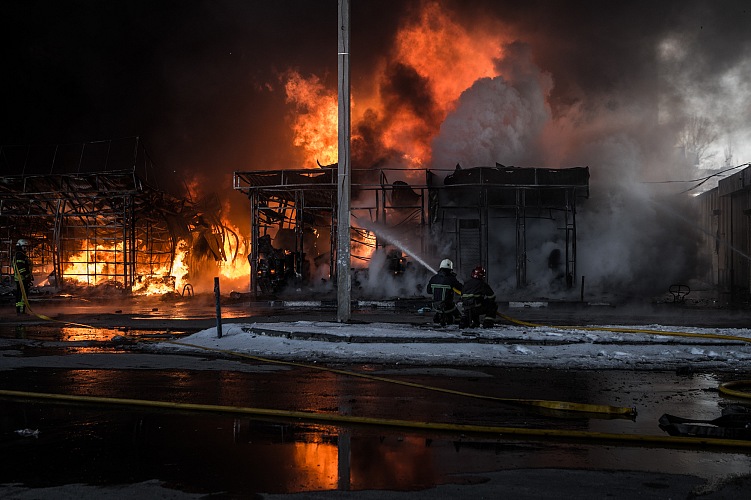 Vigili del fuoco al lavoro per spegnere l'incendio nel mercato di Saltivka, colpito da sei colpi di artiglieria pesante russa, Kharkiv, Ucraina, 2022.  Andrea Carrubba.