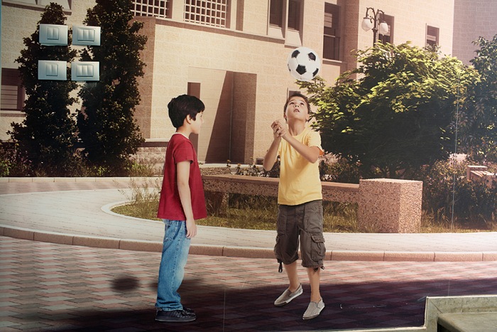 Andrea e Magda, Birth of a Utopia, Rawabi, Palestine, January 2017. In the visitor center, a promotional wall paper assembling pictures of children with the digital rendering of the future streets of Rawabi. All the models used for the marketing materials are Rawabis workers and their families.  Andrea e Magda