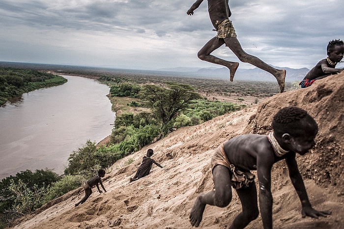 Fausto Podavini, I bambini di etnia Karo giocano nella sabbia sulle rive del fiume Omo, Etiopia, 2011, dalla mostra La fin d'un monde in esposizione allo Chemin des libellules nell'ambito di Festival Photo La Gacilly 2018.  Fausto Podavini.