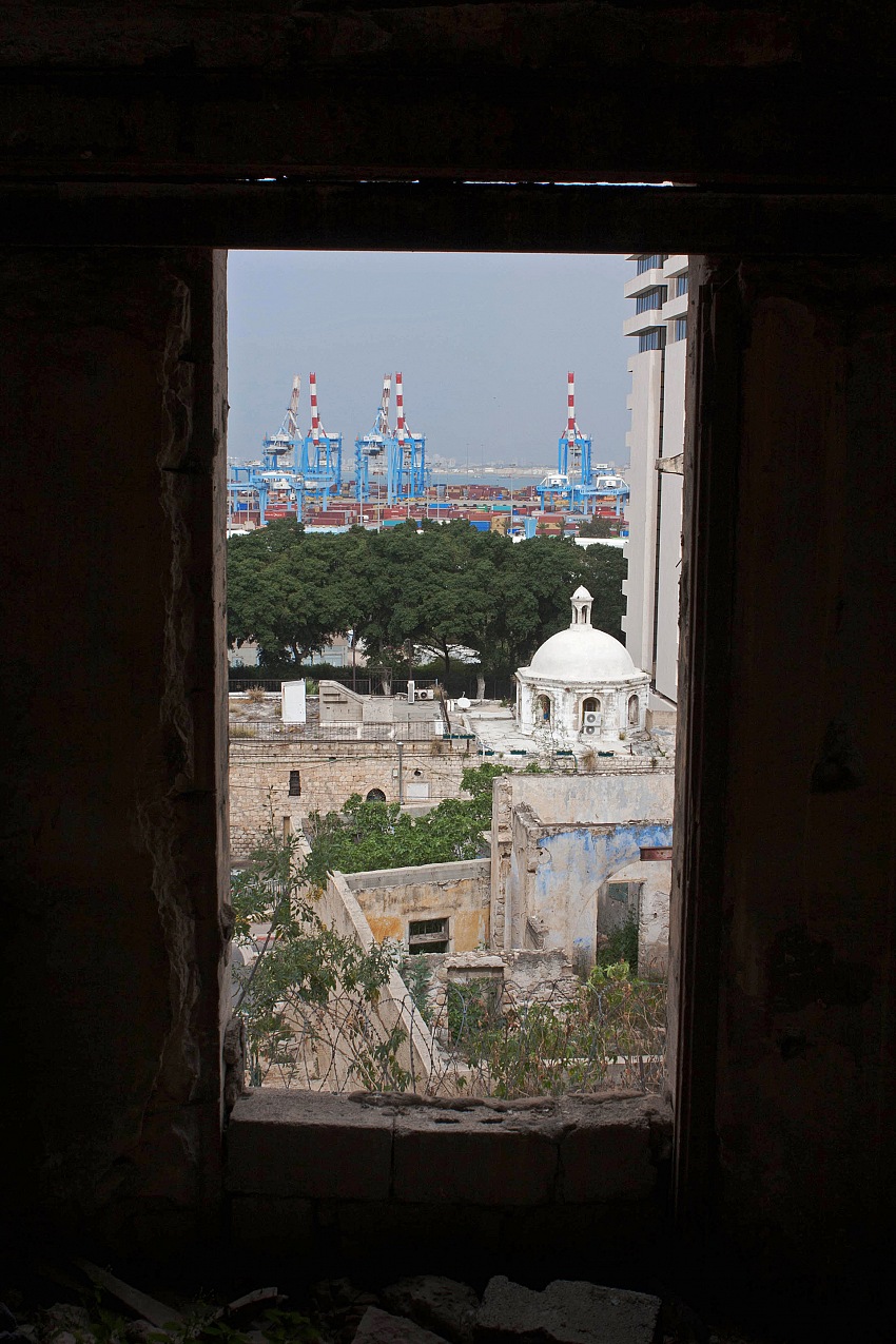 La vista dalla finestra di un'abitazine abbandonata del quartiere di Wadi Salib sullo sfondo del porto di Haifa.  Megan Van Beuge.