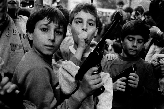 Letizia Battaglia, Festa del giorno dei morti. I bambini giocano con le armi, Palermo, 1986. Courtesy l'artista